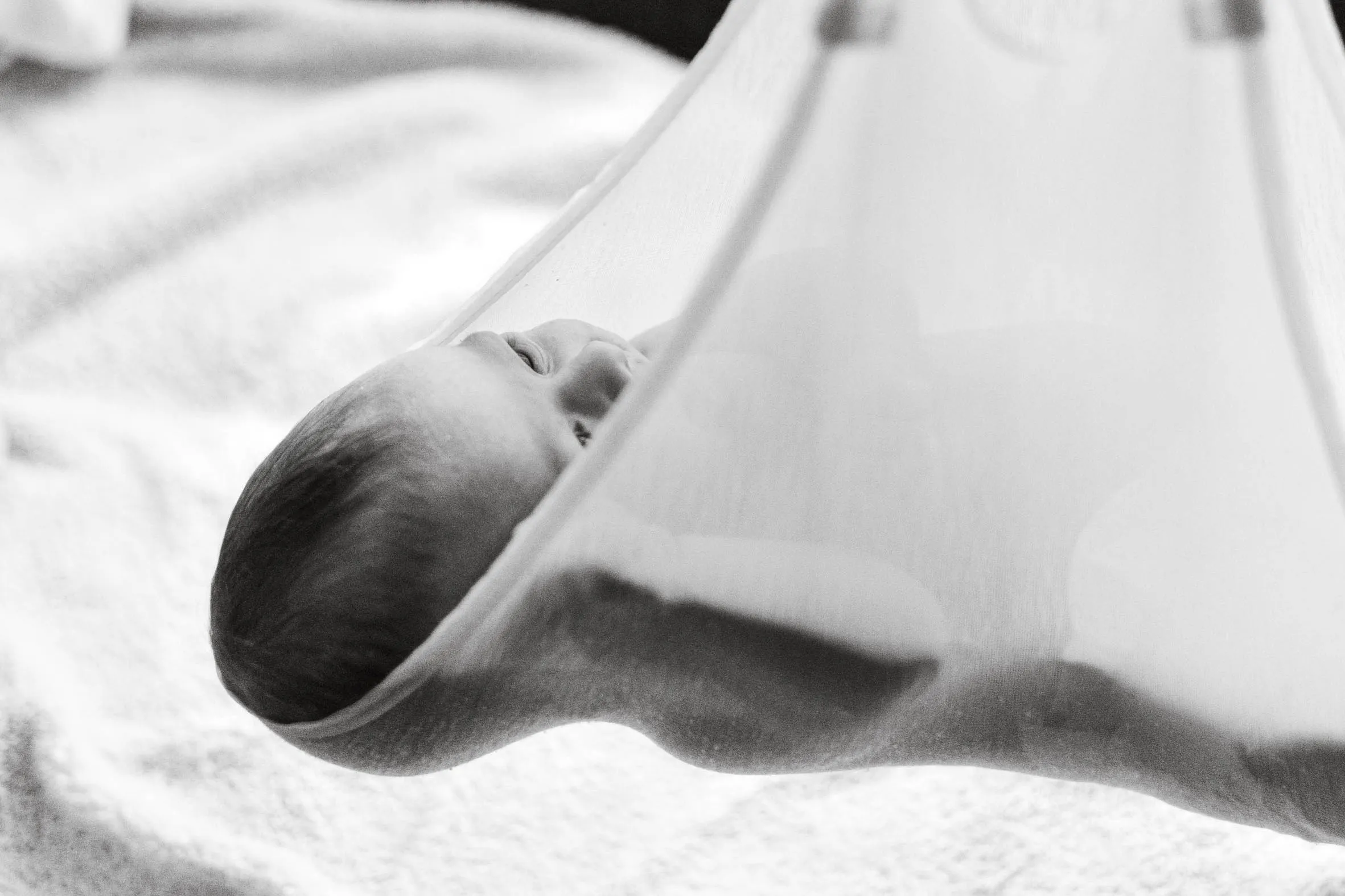 Ein Baby, welches kurz nach der Geburt mit einem Maßband vermessen wird.